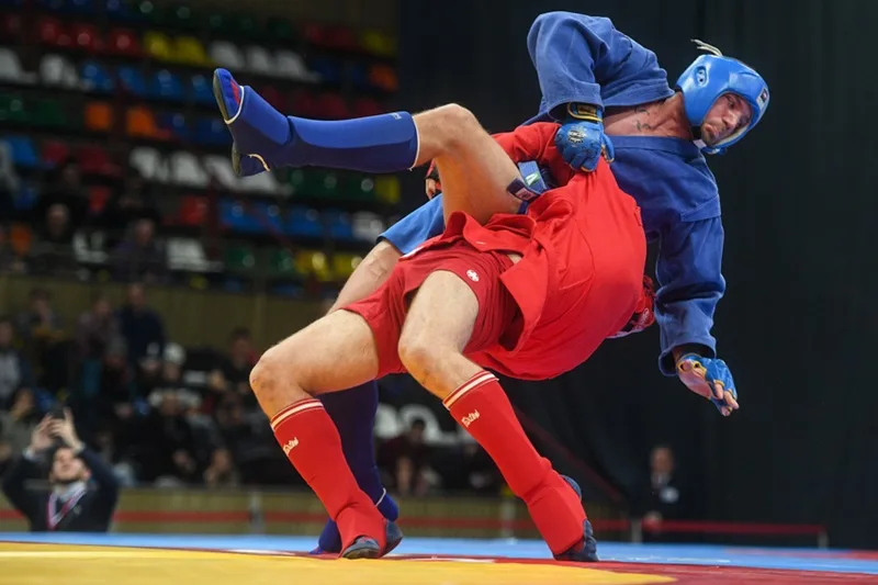 Hai võ sĩ tranh tài quyết liệt trong một trận đấu Sport Sambo trên thảm thi đấu tiêu chuẩn.